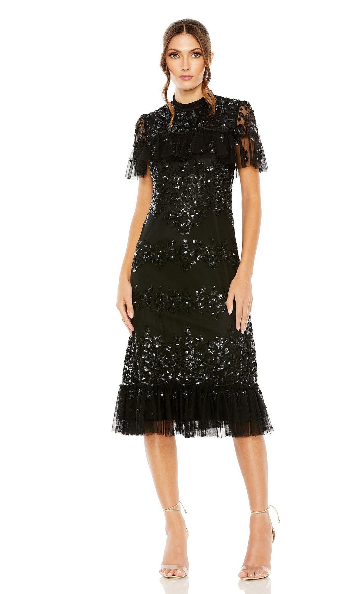 Woman wearing the Mac Duggal 9193 Black Midi Wedding Guest Dress featuring shimmering sequins, short ruffled sleeves, and a tulle hem, styled with strappy high-heeled sandals against a white background.